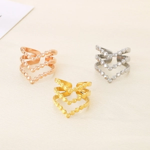 Detailed view of triple V-shaped beaded rings in gold, rose gold and silver finishes