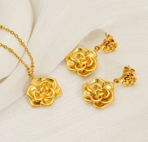 Vue macro d'un ensemble de bijoux rose dorés 18K sur fond de soie ondulée
