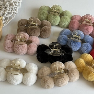 Detailed view of various colorful plush faux fur hair claw clips on white background