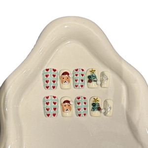 Handmade Christmas press-on nails featuring cute reindeer, trees, and glitter designs