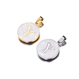 Detail of round stainless steel pendants featuring white shell inlay and letter Y
