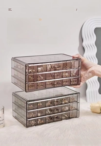 Three-layer clear acrylic jewelry box detail showing stacked stable drawer structure