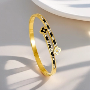 Detail of 18K gold-plated clover bangle with black enamel petals and sparkling zircon inlay