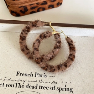 Détail de créoles vintage en fausse fourrure léopard avec tiges dorées élégantes
