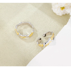 Detail of silver and gold lava texture rings with sparkling white zircon inlays