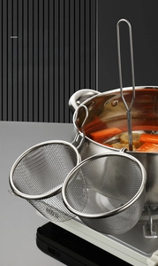 Detail showing the 304 stainless steel mesh strainer with hook hanging on a hot pot rim