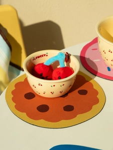 Détail d'un dessous de plat en terre de diatomée en forme de biscuit avec bol cerise