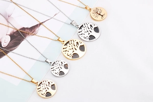 Detailed view of tree of life pendants in gold and silver finish with hollow patterns