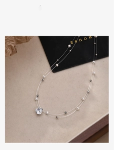 Detailed macro view of double-layer necklace with shiny zircon and pearl pendants