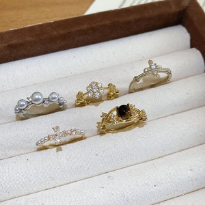 Exquisite set of five rings featuring pearls and crystals displayed in a beige jewelry box