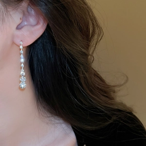 Gros plan de boucles d'oreilles à pampilles en cristal scintillant avec finition luxe