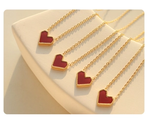 Detailed view of red heart pendant necklace with gold beaded edge on geometric display
