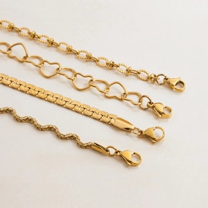 Set of four gold stainless steel bracelets with heart links and snake chains for women