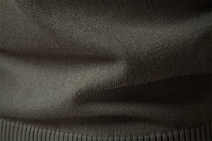 Detailed macro view of fine knit texture and ribbed hem on dark grey men's sweater