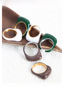 Detail of colorful resin rings with thick irregular lines and 18k gold-plated inner bands