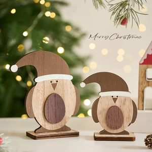 Set of two wooden penguin Christmas ornaments with Santa hats on a festive background