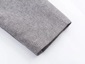 Detailed macro shot of grey herringbone fabric texture and professional sewing on sleeve