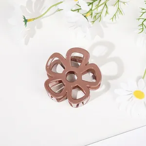 Detailed top view of a brown flower claw clip with a minimalist hollow floral design
