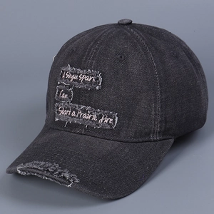 Close-up of the distressed denim baseball cap featuring embroidered inspirational text