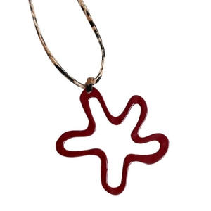 Dark red abstract star pendant with leopard print cord necklace on white background