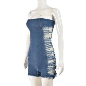 Détail d'un body en jean avec découpes latérales et franges sur tissu bleu foncé