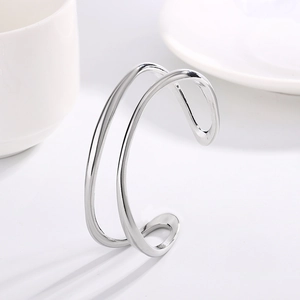 Brazalete Mobius minimalista de doble capa en plata con diseño geométrico abierto