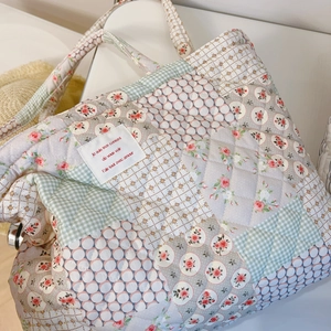 Gros plan du sac fourre-tout en coton matelassé avec motifs floraux et étiquette en tissu