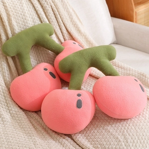Pink cherry plush pillows made of soft fleece on a knitted blanket for home decor