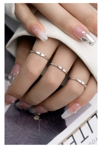Three silver zodiac rings with Scorpio and Cancer symbols on female model hand