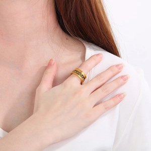 Gros plan d'une bague en acier doré avec chaîne incrustée sur le doigt d'un mannequin