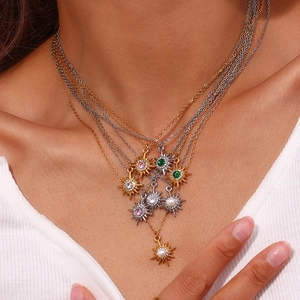 Layered 18K gold and silver necklaces with starburst pendants and colorful zircon stones
