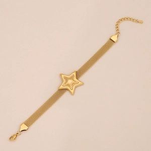 Detail view of a gold stainless steel mesh chain bracelet with a star charm and lobster clasp