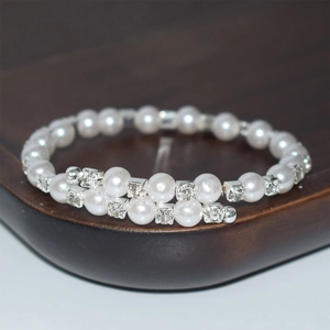 Detailed view of layered pearl bracelet with rhinestones on dark display stand