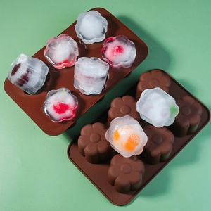 Close-up of 6-cavity flower silicone mold with fruit-infused ice cubes on green background