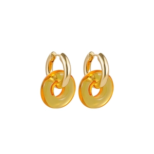 Detail of gold hoop earrings featuring transparent amber resin donut ring pendants