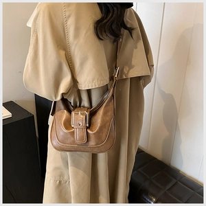 Nahaufnahme der braunen Vintage-Hobo-Tasche mit dekorativer Schnalle und breitem Gurt