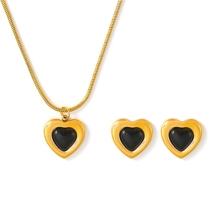 Vintage gold-plated heart necklace and earrings set with black inlay on white background