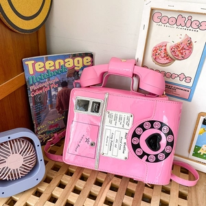 Detailed macro view of pink retro telephone crossbody bag with heart rotary dial