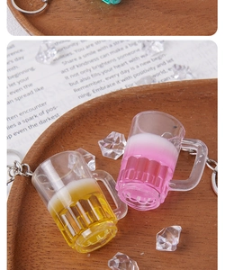 Détail macro de porte-clés miniatures de cocktail et de bière de 3,7 cm sur bois