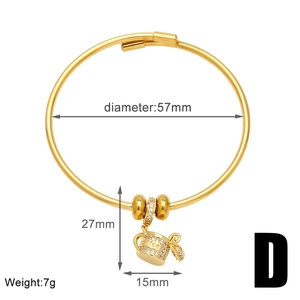 Detalle de brazalete dorado con colgante de taza de café, circonitas y grabado de Coffee