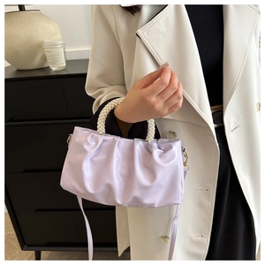 Detail of lavender pleated cloud bag featuring an elegant pearl handle on a soft PU surface