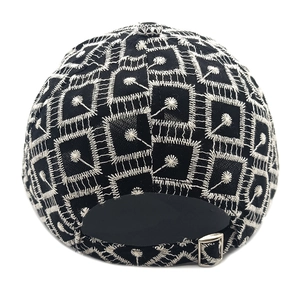 Detail of black baseball cap back with white geometric embroidery and metal buckle