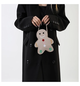 Detailed embroidery of gingerbread man face on cute brown felt handbag with strap