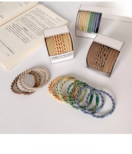Detailed close-up of high-elastic braided hair ties in Morandi tones on a white table