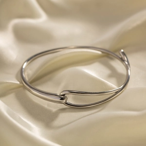 Détail d'un bracelet minimaliste en acier argenté avec fermoir à crochet sur soie