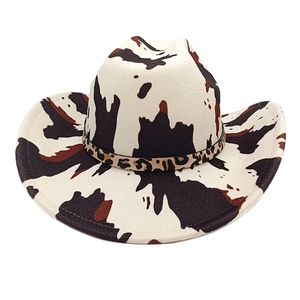 Detail of cow print western cowboy hat with a leopard pattern band on a white background