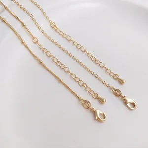 Detail of 14K gold-plated lobster clasp and 18K engraved tag on flat O-chain necklace