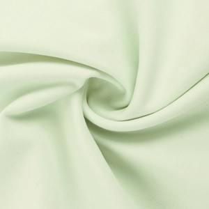 Détail macro de la texture du tissu vert menthe et du drapé élégant de la robe moulante