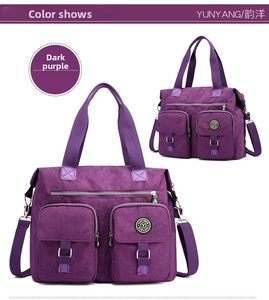 Detail of dark purple waterproof nylon travel bag with buckles and dual handles