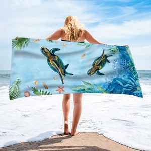 Microfiber beach towel with green sea turtles, sea stars and shells on blue gradient background